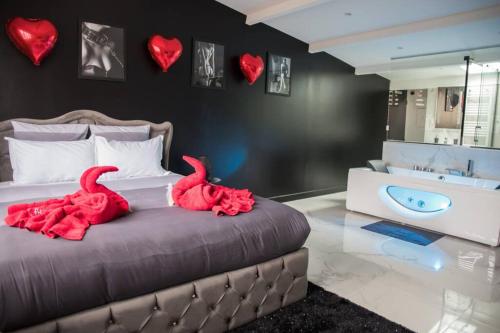 two red birds sitting on a bed with hearts on the wall at SECRET SUITE "Mr Grey" - Jacuzzi privatif - Gare RER C - Proche Paris in Brétigny-sur-Orge