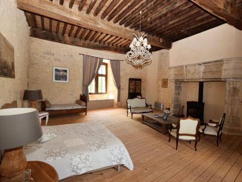 a large living room with a bed and a chandelier at Castle near Agen with Shared Pool in Saint-Caprais-de-Lerm