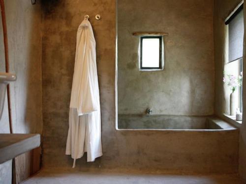 a bathroom with a tub and a robe hanging on a wall at Beautiful farmhouse in Braize with private garden in Coust