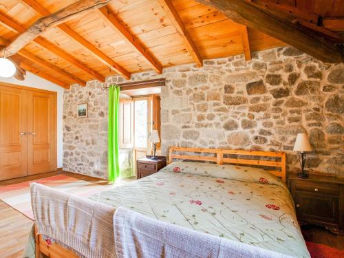 a bedroom with a bed and a stone wall at Holiday Home in Castrotañe near Sil Cañon in Castillón