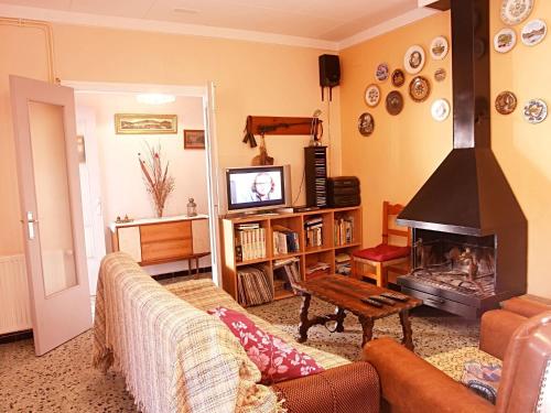 sala de estar con sofá y chimenea en Belvilla by OYO Casa Contento, en Sant Miquel de Fluvià