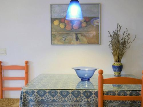 a table with a blue table cloth and a painting on the wall at Belvilla by OYO Casa Candela in Ronda