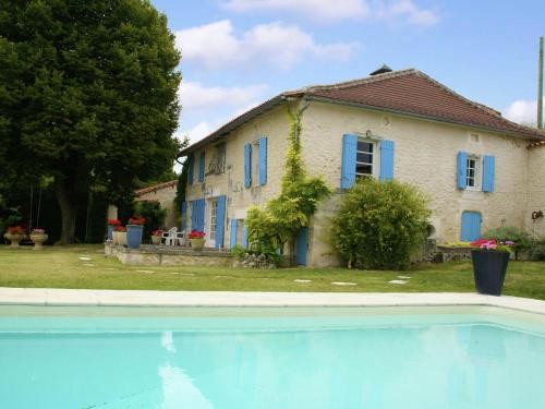 a house and a swimming pool in front of a house at Beautiful holiday home with private pool in Lusignac