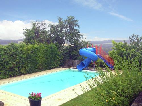 uma piscina com um escorrega azul e um parque infantil em Beautiful holiday home with private pool em Lusignac