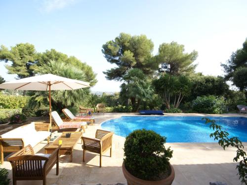 - une piscine avec des chaises, une table et un parasol dans l'établissement Villa in Saint-Paul-de-Vence with Pool Views, à Saint-Paul-de-Vence