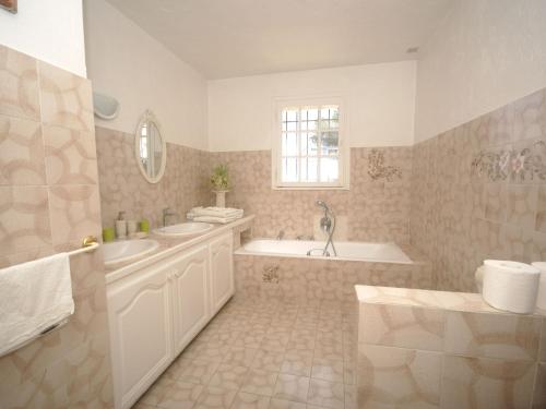 une salle de bain avec une baignoire et un lavabo et une baignoire dans l'établissement Villa in Saint-Paul-de-Vence with Pool Views, à Saint-Paul-de-Vence