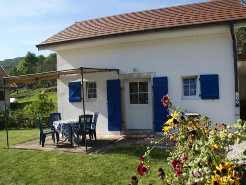 Casa blanca pequeña con mesa y sillas en Cosy holiday home with garden en Fresse-sur-Moselle