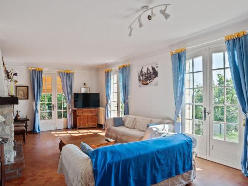 Superb villa with private garden in V lines في Vélines: غرفة معيشة مع ستائر زرقاء وأريكة