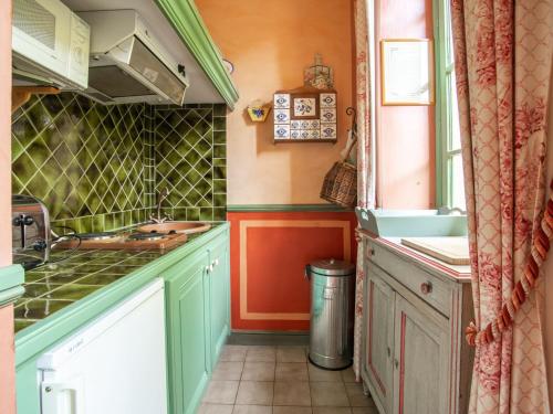 une petite cuisine avec du vert et de l'orange dans l'établissement Studio in Montbrun Castle with Pool, à Montbrun-les-Bains