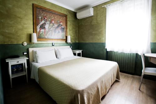 a bedroom with a bed and a painting on the wall at Hotel Diana in Ravenna