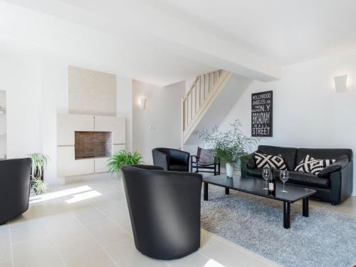 a living room with black furniture and a table at Luxury holiday home with lawn in Beaumont-en-Véron