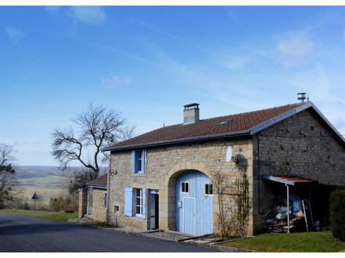 un antiguo edificio de ladrillo con un garaje blanco en Authentic holiday home in the Champagne region, en Laferté-sur-Amance