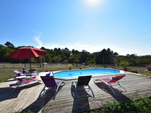 Saint-Avit-RivièreにあるLuxury house in Aquitaine with swimming poolの木製デッキのプール(椅子、パラソル付)