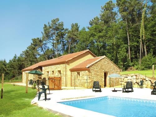 een stenen gebouw met een zwembad ervoor bij Picturesque holiday home with pool in Saint-Cernin-de-lʼHerm