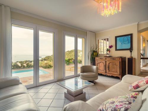 a living room with a couch and a glass table at Pretty house with sea view on the Hy res in Hyères