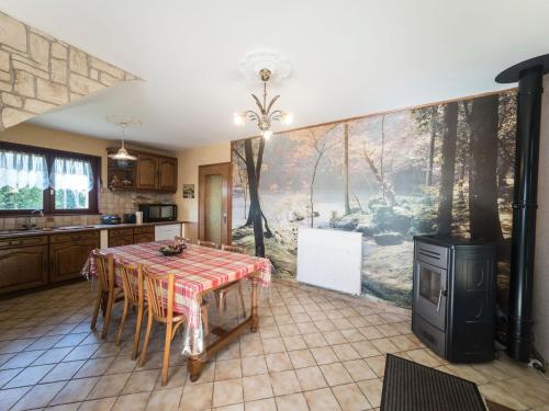 une cuisine avec une table et des chaises ainsi qu'une peinture murale. dans l'établissement House in Vosges near Cascades du Gerhard, à Girmont-Val-d'Ajol