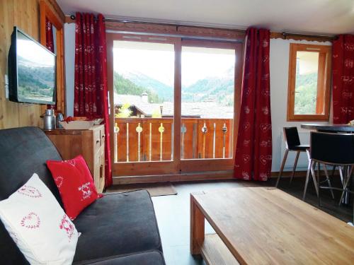 - un salon avec un canapé et une grande fenêtre dans l'établissement Simplistic Apartment in M ribel near Les 3 Vall es, à Méribel