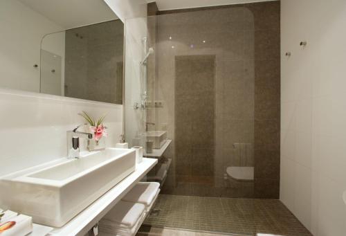 a white bathroom with a sink and a shower at Habitat Apartments Tessa in Barcelona