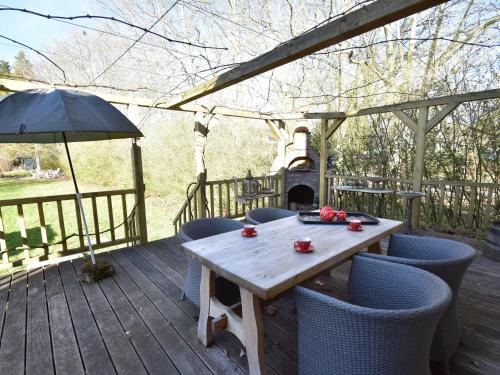einen Holztisch und Stühle auf einer Terrasse mit Kamin in der Unterkunft Cosy holiday home in Montaron with garden in Montaron