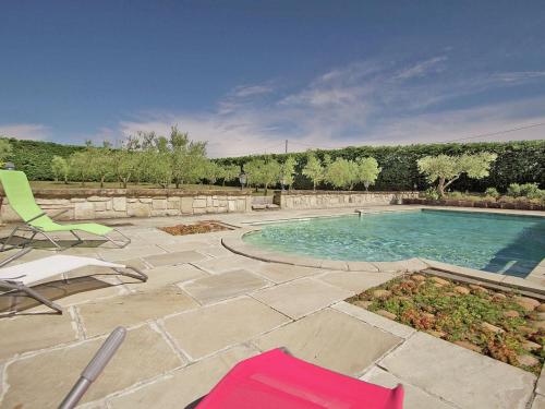 MontfrinにあるDetached villa with private pool near N mesの芝生の椅子2脚と芝生のあるスイミングプール