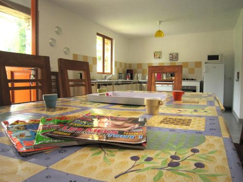 a kitchen with a table with magazines on it at Cottage in Flainville near Norman Coastline in Le Bourg-Dun