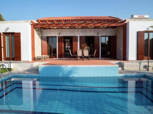 a swimming pool in front of a house at Villa in Arkadi with Pool near the Sea in Kiriánna