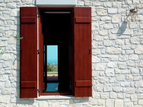 a window in a stone building with a mirror at Villa in Arkadi with Pool near the Sea in Kiriánna