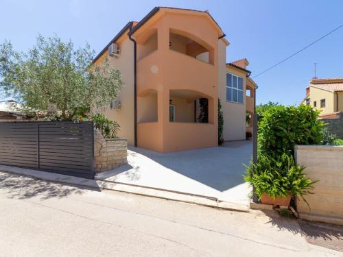 a house with a gate in front of a driveway at Spacious Holiday Home in Peroj with Private Pool in Peroj