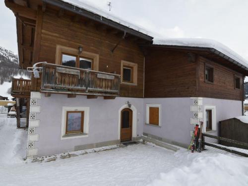 a house with a balcony on top of it in the snow at Belvilla by OYO Casa Marinella in Livigno