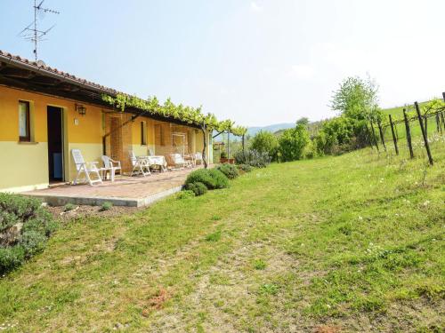 a house with a yard with chairs and a fence at Belvilla by OYO Casa Reale Quattro in Valdamonte