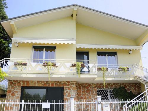 ein gelbes Haus mit weißen Geländern und Fenstern in der Unterkunft Belvilla by OYO Porto Quarantaquattro in Lazise