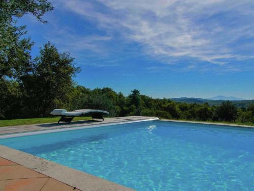 una piscina con un banco al lado en Belvilla by OYO Villa Sara, en Lucignano