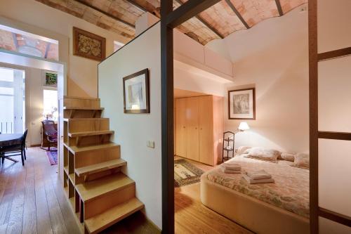 a bedroom with a bed and a staircase in a room at Habitat Apartments La Bohème in Barcelona