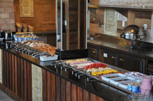 una linea a buffet con molti tipi diversi di cibo di Rio Búzios Boutique Hotel a Búzios