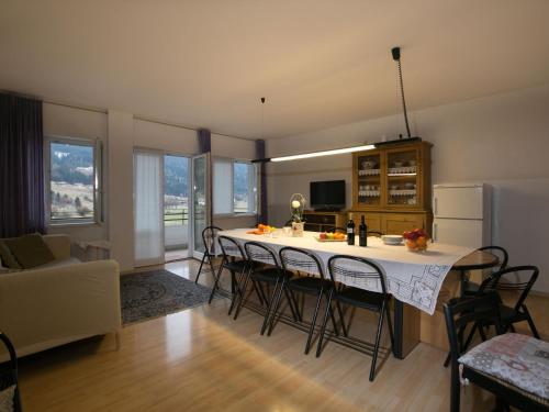 una cucina e un soggiorno con tavolo e sedie di Belvilla by OYO Fiamme a Predazzo