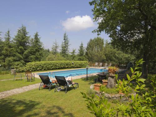 een tuin met stoelen en een zwembad bij Belvilla by OYO Uva in Radda in Chianti