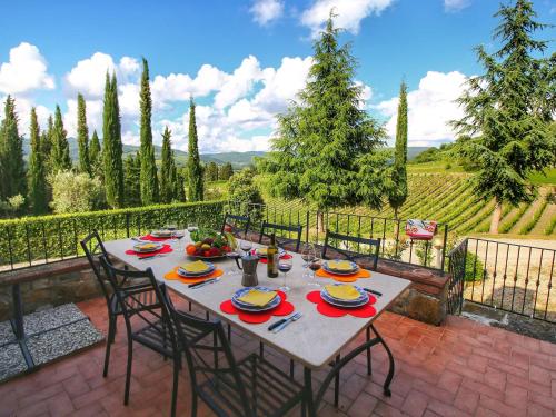 - une table avec des chaises et des assiettes de nourriture sur la terrasse dans l'établissement Belvilla by OYO Uva, à Radda in Chianti