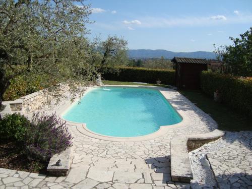 a small swimming pool in a yard with a patio at Belvilla by OYO Paneolio in Pistoia