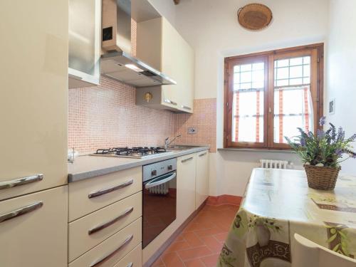 a kitchen with white cabinets and a counter top at Belvilla by OYO Mulinomanzi in Rosignano Marittimo