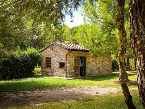 an old stone building in a park with trees at Belvilla by OYO La Provincia in Sassa