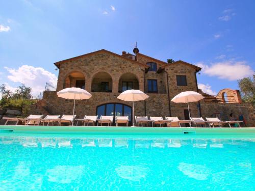una casa con piscina con sedie e ombrelloni di Belvilla by OYO Era una Volta a Montenero