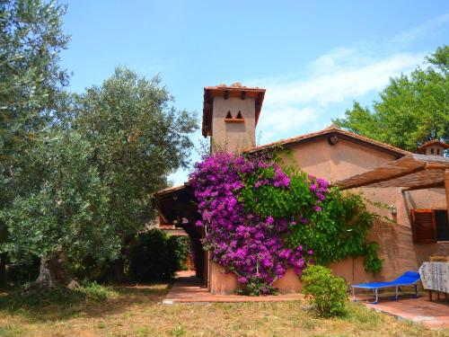 una casa con fiori viola su un lato di Belvilla by OYO Comfy Holiday Home with Garden a Monte Argentario