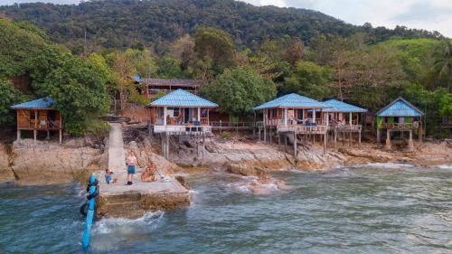 un groupe de maisons sur la rive d'une masse d'eau dans l'établissement KohChangResortRanong, à Koh Chang Ranong