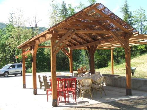 einen Holzpavillon mit Tischen und Stühlen auf einer Terrasse in der Unterkunft Belvilla by OYO Appartamento Yassine in Tredozio