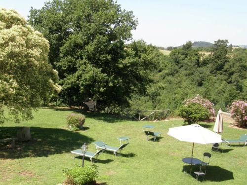 a group of chairs and an umbrella in the grass at Belvilla by Oyo Sorano in Sorano