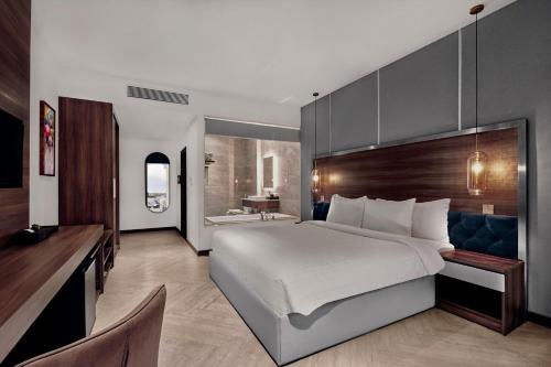 a bedroom with a large bed and a desk at CHAU KHUONG HOTEL in Long Xuyên