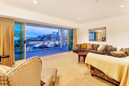 a living room with a couch and a large window at QV Stays Absolute Waterfront Stunner in Auckland