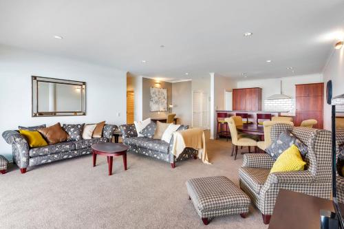 a living room with couches and a dining room at QV Stays Absolute Waterfront Stunner in Auckland
