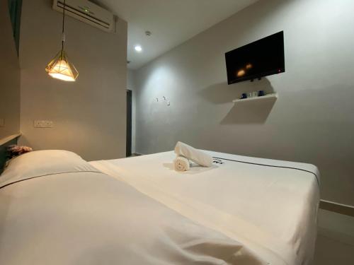 a bedroom with a white bed with a towel on it at Seeds Hotel Wangsa Maju in Kuala Lumpur