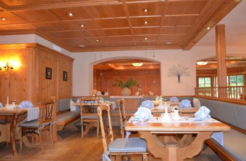 comedor con mesas y sillas de madera en Almhotel Told, en Grän